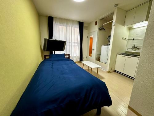 a bedroom with a blue bed in a room at 1-3サン　地下鉄徒歩圏内サービスアパ―トメントSAPPORO Shiroish iStation エアコンネット完備 in Tsukisappu