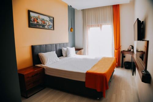 Un dormitorio con una cama con una manta naranja. en D&D HOTEL, en Nilüfer