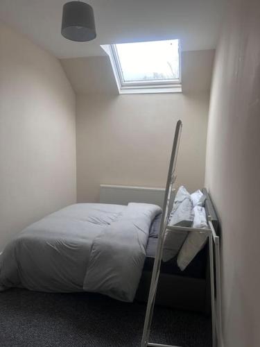 a small bedroom with a bed with a window at City centre apartment in Sunderland