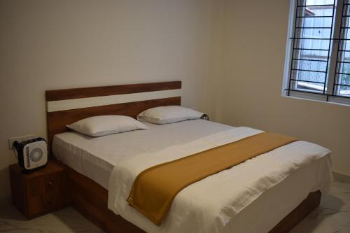 a bedroom with a large bed with a wooden headboard at Stellar homes Ooty in Ooty