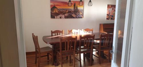 une table à manger et des chaises avec un tableau mural dans l'établissement Ice Alley Home Città Alta, à Bergame