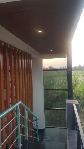 a room with a view of a field with a window at Padmaa Hampi Echo Villa in Hampi