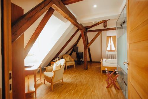 an attic room with a desk and a bedroom at Hotel "Alter Pfarrhof" in Nabburg