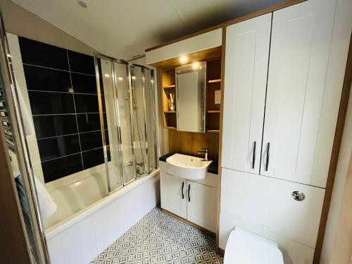 a bathroom with a sink and a shower and a toilet at Country Cabin with Hot Tub in York
