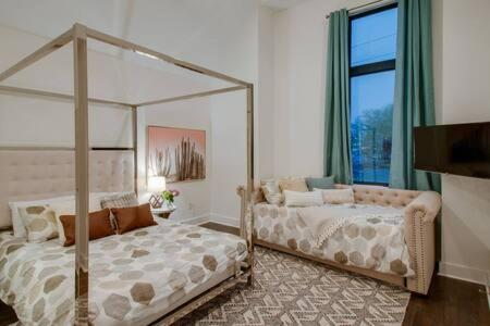 a bedroom with two beds and a large window at The Dawson - Gulch Elegance, Green Rooftop Retreat in Nashville