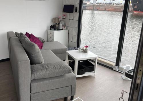 a living room with a couch and a table at Hausboot Lobster Bremerhaven in Bremerhaven