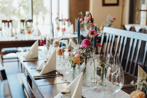 a long table with white napkins and flowers on it at Hotel "Alter Pfarrhof" in Nabburg