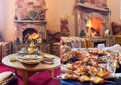 sala de estar con mesa con comida y chimenea en Villa Mouloud réservée aux familles, en Arrougou
