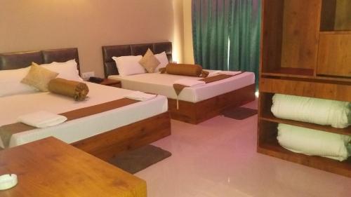a room with two beds and a table at The Piku's Inn in Digha