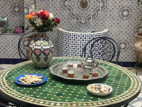 a table with a plate of food and a vase at HOTEL EL AMAL in Marrakech