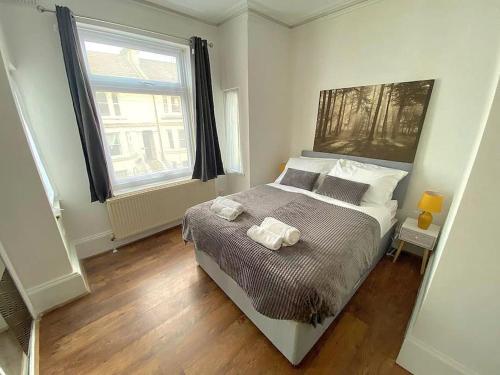 a bedroom with a bed with two towels on it at Gravesend Spacious 2 bedroom Apartment - 2 mins to Town Centre and Train Station in Kent