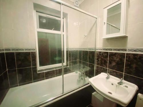 y baño con lavabo, bañera y espejo. en Gravesend Spacious 2 bedroom Apartment - 2 mins to Town Centre and Train Station, en Kent