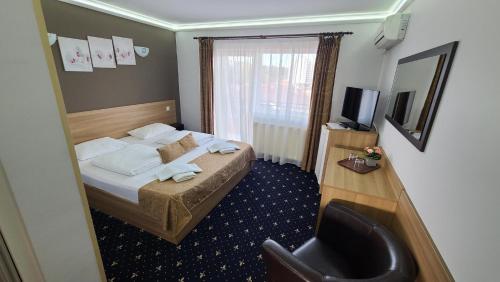 a hotel room with a bed and a television at Vila Cristal in Baile Felix