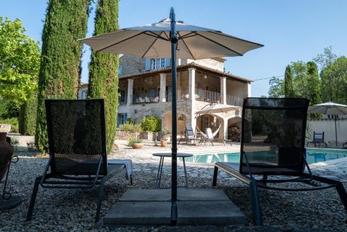 Saint-André-de-Cruzières的住宿－Gîte Le Bel Endroit，游泳池旁的两把椅子和一把遮阳伞