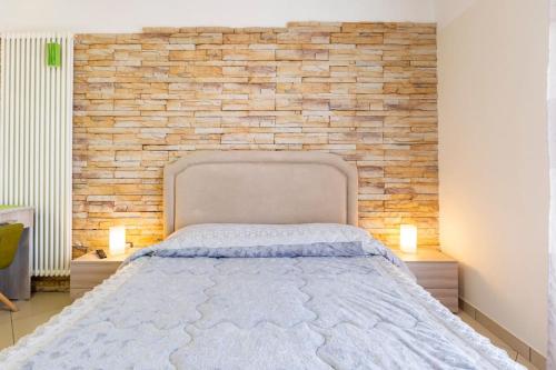 a bed in a bedroom with a brick wall at La Casa di Annette in Fisciano