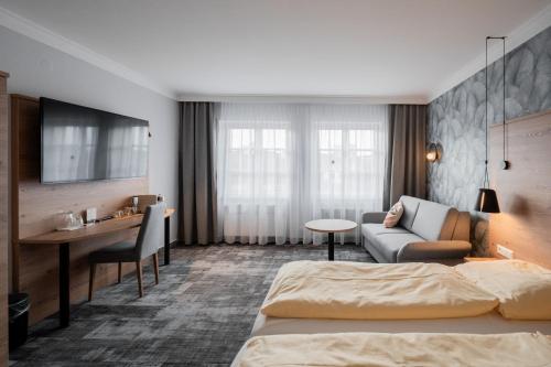エーインゲンにあるHotel Adler - Paulas Albのベッドとデスクが備わるホテルルームです。