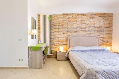 a bedroom with a bed and a brick wall at La Casa di Annette in Fisciano