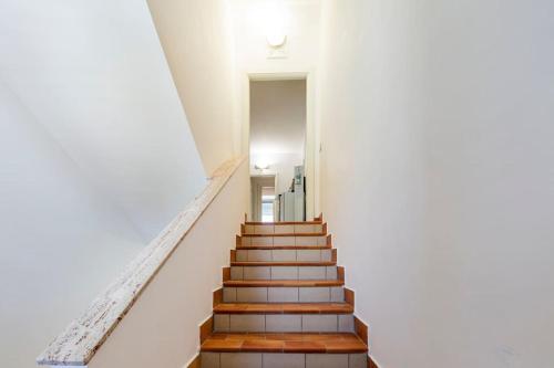 a staircase in a white building with wooden steps at La Casa di Annette in Fisciano