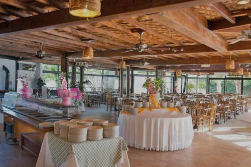 un gran salón de banquetes con mesas, sillas y ventanas en Paphos gardens studio suite, en Pafos