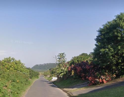 a road with trees and flowers on the side of it w obiekcie Home away from Home in La Mercy w mieście La Mercy