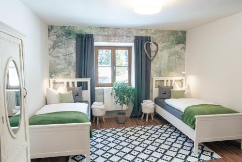 2 Betten in einem Schlafzimmer mit Grün und Weiß in der Unterkunft Gipfelkönig in Bayrischzell