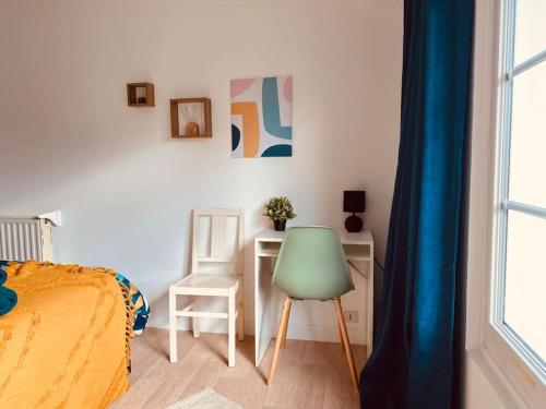 a bedroom with a bed and a desk and a chair at Le Soleil Parisien in Villejuif