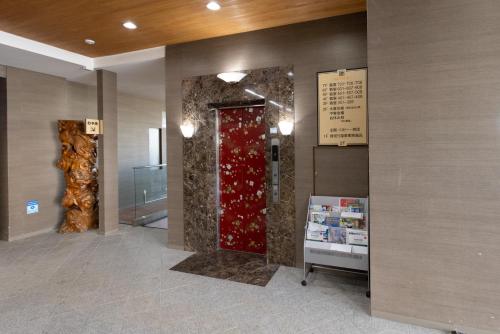 a lobby with a red door in a building at Shirahama Onsen Kisyu Hanto in Shirahama