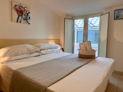 Un dormitorio con una gran cama blanca con ventana. en Sperlonga Paradise Apartment Complex, en Sperlonga