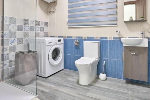y baño con lavadora y lavamanos. en Two Bedroom Apartment in Xemxija, St. Paul's Bay, en St Paul's Bay
