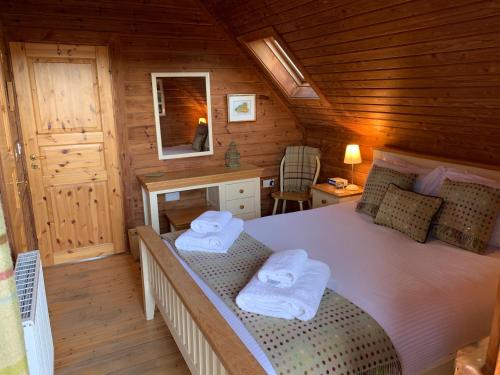 - une chambre avec un lit dans une cabane en bois dans l'établissement Horsey Reach Lodge, à Stanley