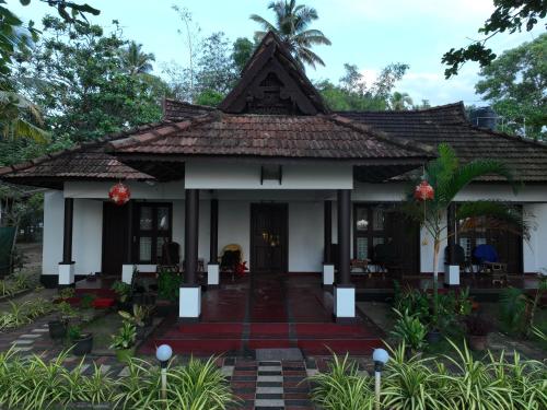 a house in the middle of a garden at Marari SeaLap Beach Villas in Mararikulam
