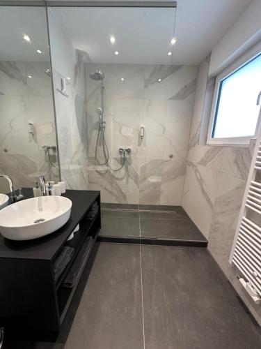 a bathroom with a shower and a sink and a sink at 1-LIVING Apartment Houses in Nuremberg