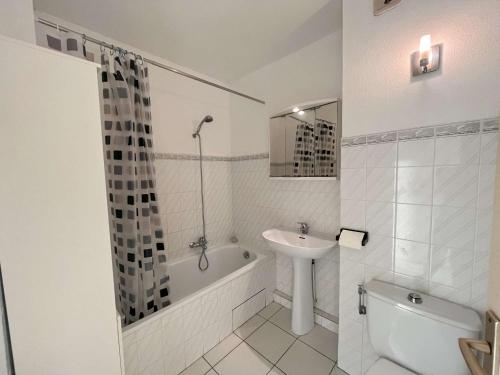 a white bathroom with a sink and a tub and a toilet at Charmant T2/Mezzanine avec Piscine et Terrasse, à 5 min de la Plage, St-Raphaël - FR-1-226A-148 in Boulouris-sur-Mer