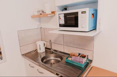 eine kleine Küche mit einer Spüle und einer Mikrowelle in der Unterkunft Boulevard One in General Pico