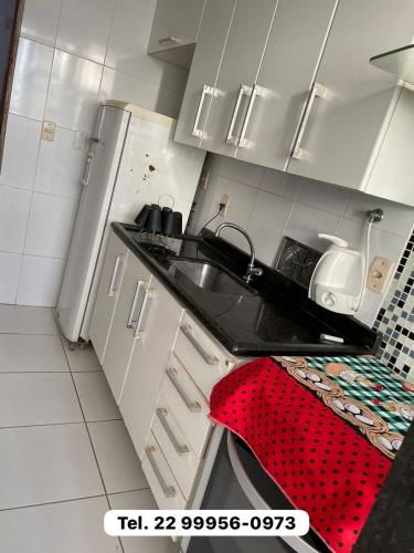 a kitchen with a sink and a red towel at Apto Carioca Shopping in Campos dos Goytacazes