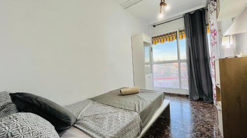 a bedroom with a bed and a window with a window at Apartamento Compartido con Vista al Puerto Valencia in Valencia