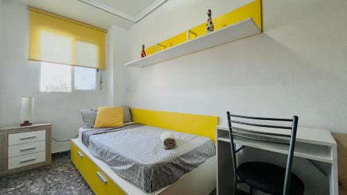 a bedroom with a desk and a bed with a chair at Apartamento Compartido con Vista al Puerto Valencia in Valencia