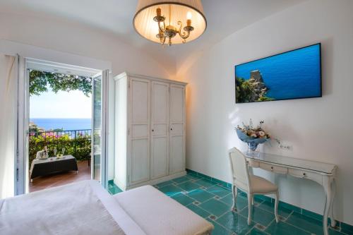 a bedroom with a bed and a desk and a window at Hotel Pellegrino in Praiano