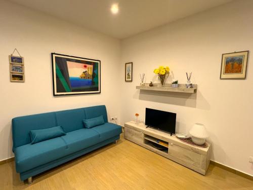 ein Wohnzimmer mit einem blauen Sofa und einem TV in der Unterkunft Marta's Home in Molfetta