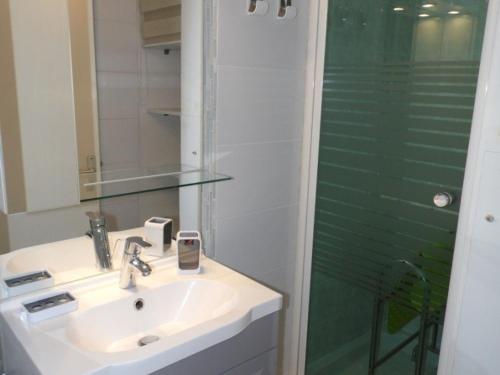 une salle de bain avec un lavabo et une douche dans l'établissement Maison mitoyenne climatisée avec terrasse et piscine à Marseillan - FR-1-326-474, à Marseillan