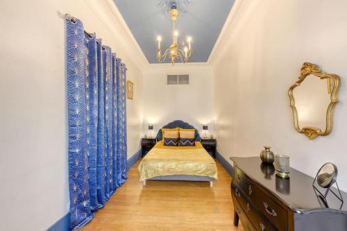 een slaapkamer met een bed, een dressoir en een spiegel bij « La cour royale » appartement prestigieux à 50m du château de Versailles in Versailles