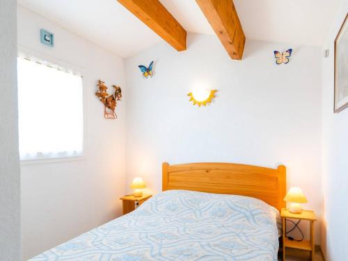 une chambre avec un lit et deux lampes et une fenêtre dans l'établissement Villa cosy avec terrasse et 2 chambres - 5 pers. max à Saint Pierre La Mer, proche plage - FR-1-409-7, à Saint Pierre La Mer