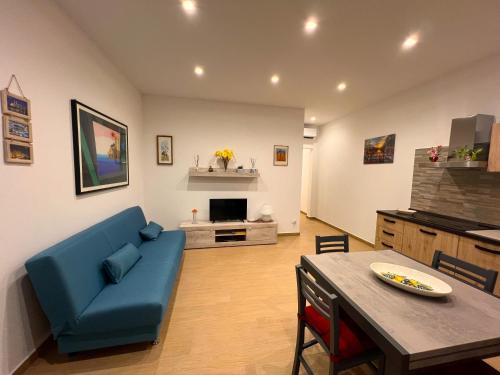 ein Wohnzimmer mit einem blauen Sofa und einem Tisch in der Unterkunft Marta's Home in Molfetta