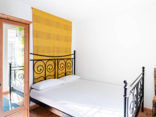 - une chambre avec un lit doté d'une tête de lit jaune dans l'établissement Villa 4 pièces lumineuse avec terrasse, garage, 6 couchages, proche plage et commerces, Narbonne-Plage - FR-1-409-19, à Narbonne