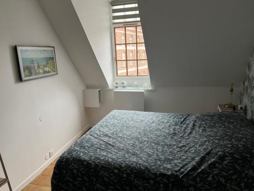 a bedroom with a bed and a window at Chambre privée Place aux oignons in Lille