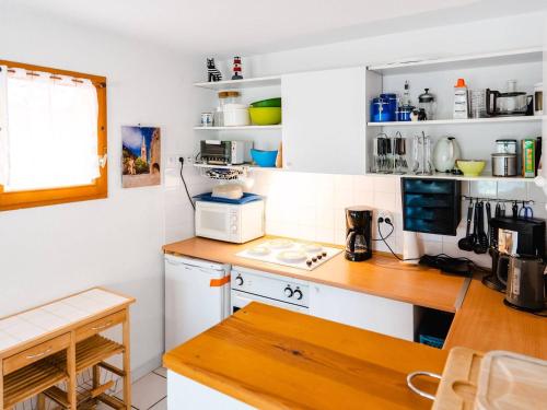 une cuisine avec des armoires blanches et un comptoir dans l'établissement Pavillon Climatisé 3 Pièces avec Terrasse et Garage, Proche Plage - 4 Couchages - FR-1-409-68, à Narbonne-Plage