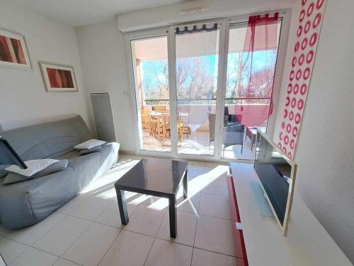 un salon avec un canapé et une table dans l'établissement Appartement cosy 2 pièces avec accès direct plage, piscine et parking privé à Marseillan - FR-1-326-512, à Marseillan