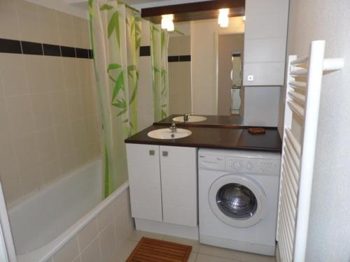 une salle de bain avec une machine à laver et un lavabo dans l'établissement Appartement cosy 2 pièces avec accès direct plage, piscine et parking privé à Marseillan - FR-1-326-512, à Marseillan