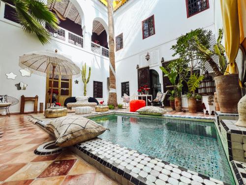 an indoor swimming pool in a house with an umbrella at DAR AURORA in Marrakesh