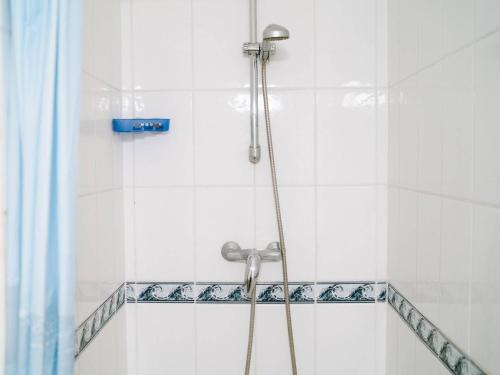 La salle de bains est pourvue d'une douche et de carrelage blanc. dans l'établissement Villa moderne avec jardin et terrasse, 2 chambres + mezzanine, proche plage - Narbonne-Plage - FR-1-409-102, à Narbonne-Plage